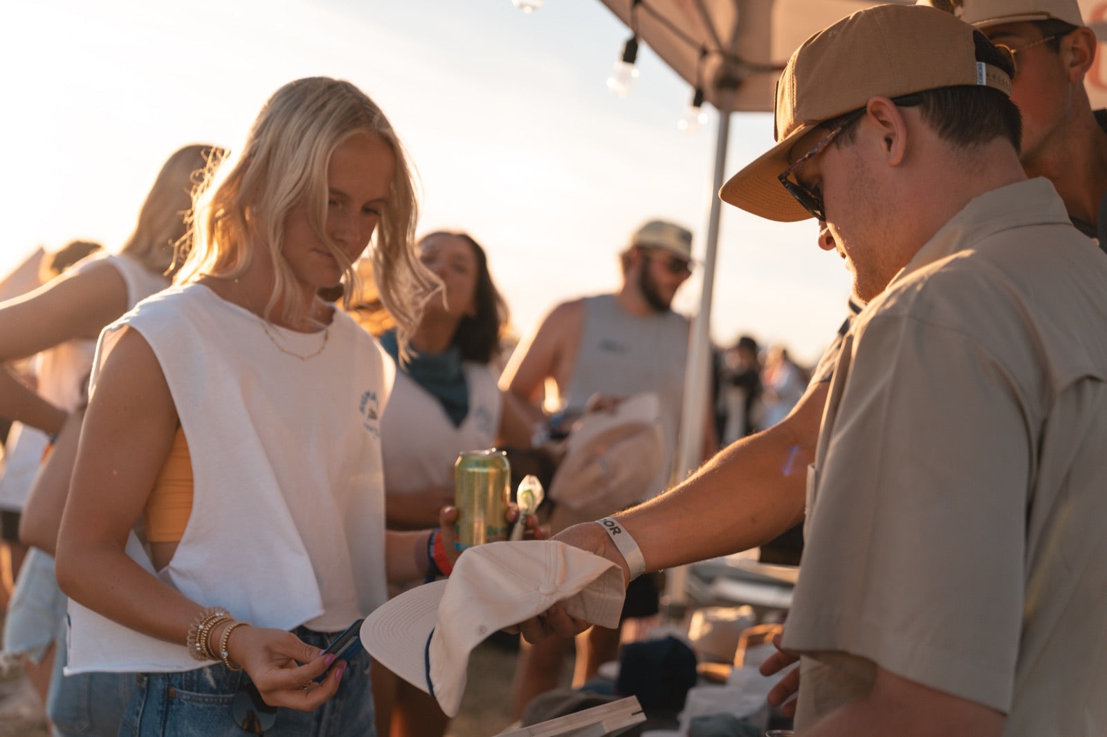 Concho merch table at a show, handing a custom hat to a fan